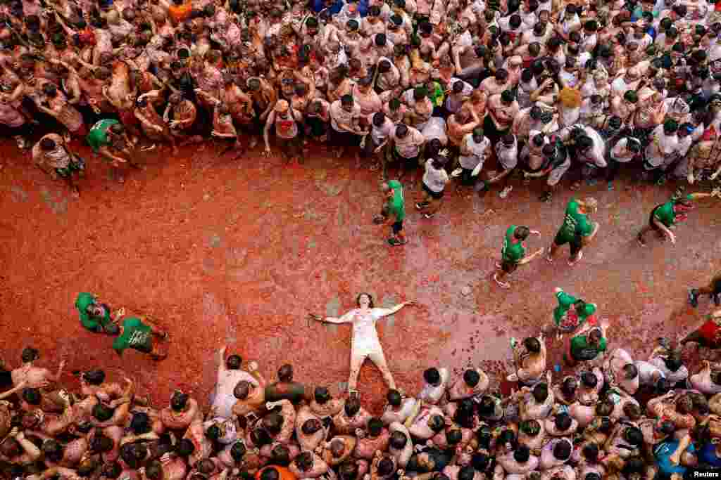 A participant lies in tomato pulp during the 'La Tomatina' festival in Bunol, near Valencia, Spain, Aug. 28, 2024.