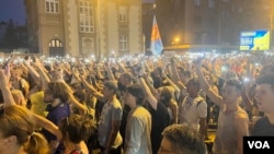 ARHIVA - Građani drže telefone sa upaljenim svetlima ispred sedišta beogradske policije, 8. jula 2023. (Foto: VOA/Rade Ranković)