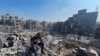 Seorang warga Palestina tampak terduduk berada di antara reruntuhan bangunan kamp pengungsi Jabalia yang hancur akibat serangan udara Israel, pada 1 November 2023. (Foto: Reuters/Mohammed Al-Masri)
