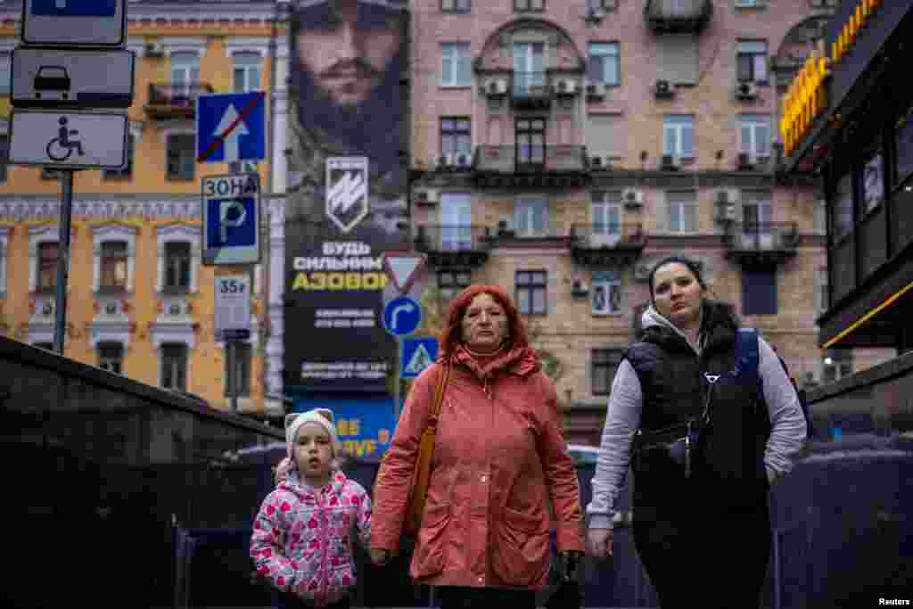 Una mujer y un niño caminan cerca de un cartel de reclutamiento para la Brigada de Asalto Azov de la Guardia Nacional de Ucrania, en Kiev, Ucrania, el 8 de noviembre de 2023. El informe del miércoles se refería a 35 niños de la ciudad ucraniana de Antratsyt, ocupada por Rusia, en el este de Ucrania. Según las autoridades bielorrusas, fueron enviados a la ciudad de Mogilev, en el este de Bielorrusia. 