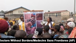 FILE - This photo supplied by Doctors Without Borders shows health workers educating children in Goma, Congo, about the symptoms of mpox disease, May 31, 2023.