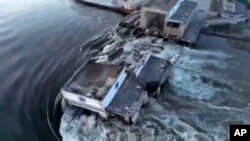 En esta imagen tomada de un video publicado por la Oficina Presidencial de Ucrania, el agua atraviesa un avance en la represa Kakhovka en Kakhovka, Ucrania, el martes 6 de junio de 2023.
