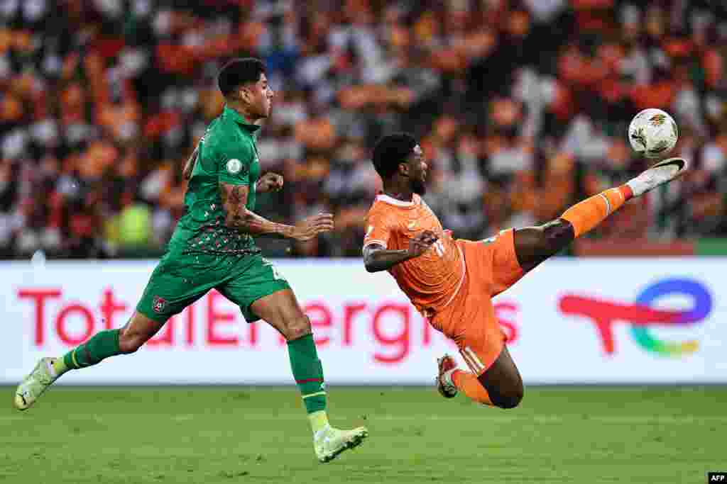 O avançado #4 Marcelo da Guiné-Bissau disputa a bola com o avançado #11 Jean Philippe Nils Stephan Krasso da Costa do Marfim durante o jogo de futebol do grupo A da Taça das Nações Africanas 2023 (Foto de FRANCK FIFE / AFP)