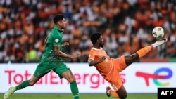 O avançado #4 Marcelo da Guiné-Bissau disputa a bola com o avançado #11 Jean Philippe Nils Stephan Krasso da Costa do Marfim durante o jogo de futebol do grupo A da Taça das Nações Africanas 2023 (Foto de FRANCK FIFE / AFP)