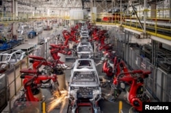Lengan robot merakit mobil di jalur produksi kendaraan listrik Leapmotor di sebuah pabrik di Jinhua, Provinsi Zhejiang, China, 26 April 2023. (Foto: China Daily via REUTERS)