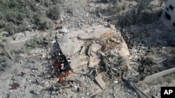 FILE - Palestinians look for survivors after an Israeli bombardment of the Gaza Strip in Deir Al-Balah, Oct. 22, 2023. U.N. humanitarian monitors say at least 2,700 people, including 1,500 minors, are missing and believed buried under the rubble since the Israel-Hamas war began. 