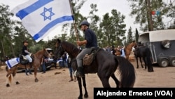 Un hombre a caballo porta una bandera de Israel poco antes de iniciar la cabalgata por la liberación de Idan Shtivi, el 5 de diciembre de 2023.