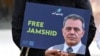 Seorang demonstran membawa poster berisi gambar Jamshid Sharmahd dalam aksi menuntut pembebasan terhadap Sharmahd di luar Kementerian Luar Negeri Jerman di Berlin, pada 31 Juli 2023. (Foto: AFP/Ina Fassbender)