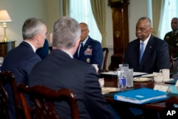 Defense Secretary Lloyd Austin, right, listens during a meeting with NATO Secretary General Jens Stoltenberg, left, at the Pentagon, near Washington, Jan. 29, 2024.