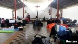 ARCHIVO - Inmigrantes haitianos duermen en una iglesia en Inapari, en la frontera de Perú con Brasil, el 2 de febrero de 2012.