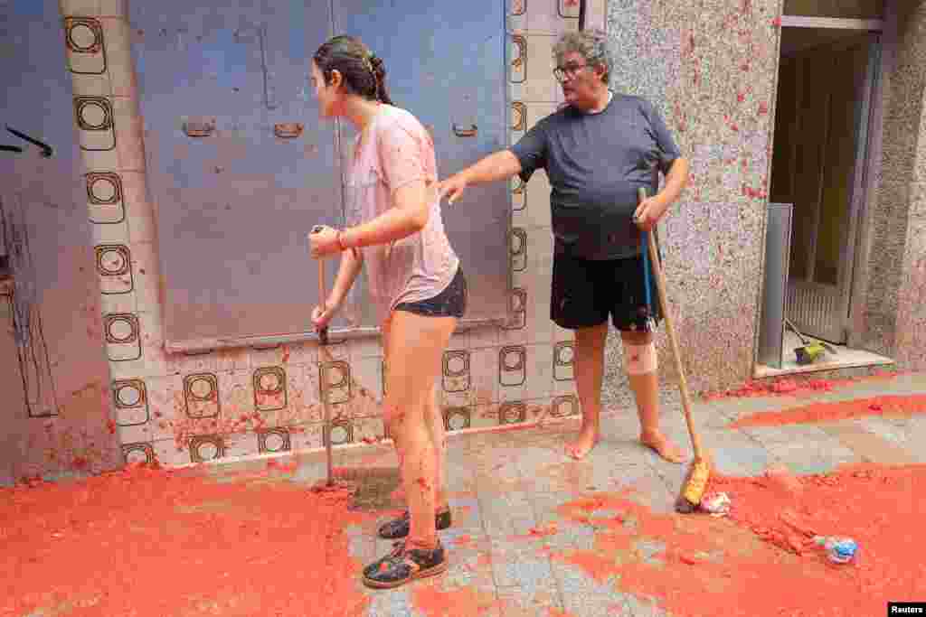 Moradores locais limpam a polpa de tomate após o festival anual de luta de alimentos “La Tomatina” em Bunol, perto de Valência, Espanha, 28 de agosto de 2024. 