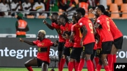 O avançado angolano #9 Zini celebra com os colegas de equipa depois de marcar o segundo golo da sua equipa durante o jogo de futebol do grupo D da Taça das Nações Africanas (CAN) 2024 contra o Burkina Faso a 23 de janeiro de 2024