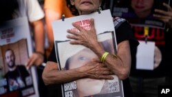 Familiares y amigos de los secuestrados durante el ataque transfronterizo de Hamás del 7 de octubre en Israel, sostienen fotografías de sus seres queridos en una protesta pidiendo su regreso frente a la Knesset, el parlamento de Israel en Jerusalén, el 6 de noviembre de 2023.