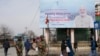 Sejumlah anggota pasukan paramilliter berjaga di dekat papan iklan yang menampilkan pengumuman kunjungan perdana Menteri India Narendra Modi ke Srinagar, Kashmir, pada 6 Maret 2024. (Foto: AP/Mukhtar Khan)