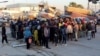 FILE - Migran menunggu di pelabuhan Sfax, setelah dihentikan oleh penjaga pantai Tunisia di laut saat mereka mencoba menyeberang ke Italia, 26 April 2023.