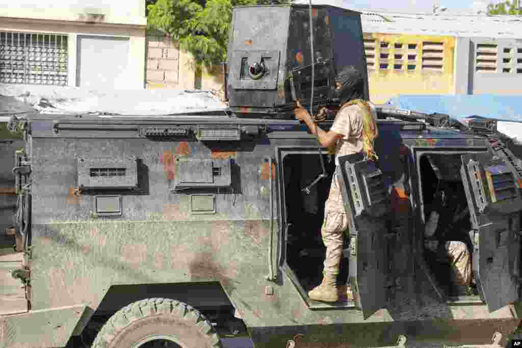 Un miembro de la policía se cubre en un carro blindado durante una operación antipandillas en Puerto Príncipe, la capital de Haití, el viernes 1 de marzo de 2024.