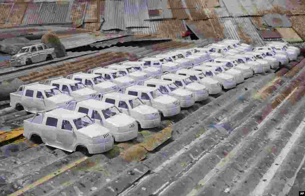 Pequeños autos ensamblados por reclusos para vender en la feria Alasita se secan en el techo de la cárcel para hombres de San Pedro en La Paz, Bolivia, Bolivia, 18 de enero de 2024. En la feria anual, que comienza el 24 de enero, la gente compra pequeñas réplicas de cosas que sueñan tener. (Foto AP/Juan Karita) 