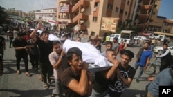 Palestinos cargan cuerpos de la familia Abu Rayash muerta en bombardeos israelíes. En Rafah, Franja de Gaza, el 12 de octubre de 2023. [AP]