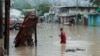 Un hombre camina por una calle inundada después de una fuerte lluvia en Puerto Príncipe, Haití, el sábado 3 de junio de 2023.