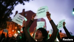 ARCHIVO - Un colectivo feminista en Bogotá sostiene pancartas con los nombres de las víctimas de feminicidio entonando la canción "un violador en el camino", que se hizo famosa en Chile. 