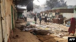 FILE - People walk among objects in the market of El Geneina, the capital of West Darfur, April 29, 2023, as fighting continues in Sudan between the forces of two rival generals.