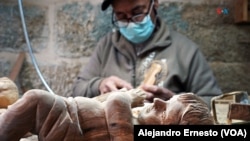 Un palestino talla figuras religiosas en madera de olivo, artesanías que no saben cuándo venderán por la ausencia de turistas debido al conflicto Israel-Hamás, en Belén, Cisjordania, el 7 de diciembre de 2023. 