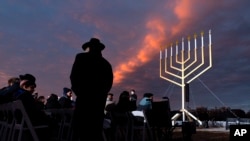 Un hombre regresa a su asiento durante el encendido nacional de la Menorá de Janucá, el jueves 7 de diciembre de 2023, en la Elipse cerca de la Casa Blanca en Washington. (Foto AP/Jacquelyn Martin)