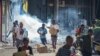 People run with merchandise as crowds leave shops with looted goods amid a state of unrest in Port Moresby on Jan. 10, 2024. 