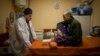 El médico ucraniano Yurii Kuznetsov habla con la víctima de las minas terrestres Oleksandr Kolisnyk en el hospital de Izium, Ucrania, el domingo 19 de febrero de 2023. (Foto AP/Vadim Ghirda, Archivo)
