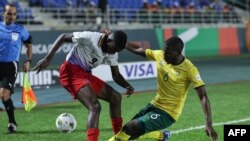 Aubrey Modiba, da África do Sul, em lance com Bethuel Muzeu, da namíbia, durante a partida de futebol do grupo no CAN.