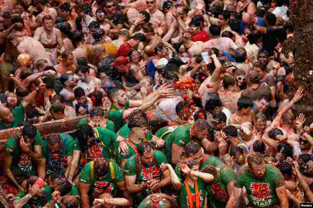 Foliões atiram tomates uns aos outros durante o festival de luta de comida “La Tomatina” em Bunol, perto de Valência, Espanha, a 28 de agosto de 2024.