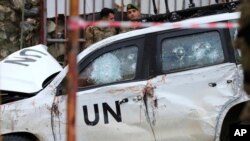 Dua tentara Lebanon berdiri di belakang kendaraan PBB yang rusak setelah konvoi penjaga perdamaian PBB (UNIFIL) diserang oleh warga di desa Al-Aqbiya, Lebanon selatan, pada 15 Desember 2022 dan menewaskan seorang anggota UNIFIL (foto: dok). 