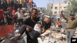 Yon palestinyen pote yon tifi li rale soti nan yon kay ki detwi nan bonbadman Izrayelyen vil Rafah nan Gaza, 23 Oktob, 2023.