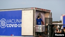 Un lote de vacunas contra COVID-19 recibidas bajo el mecanismo COVAX son descargadas en el aeropuerto internacional de San Salvador, El Salvador, el 11 de marzo de 2021.