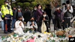 People pray for victims of a deadly accident following Saturday night's Halloween festivities on a street near the scene in Seoul, South Korea, Nov. 1, 2022. 