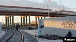 Migrantes venezolanos solicitantes de asilo que fueron expulsados de regreso a México desde El Paso, Texas, EEUU, hacen campamento improvisado junto al Puente Internacional Paso del Norte en Ciudad Juárez, México, el 18 de octubre de 2022.