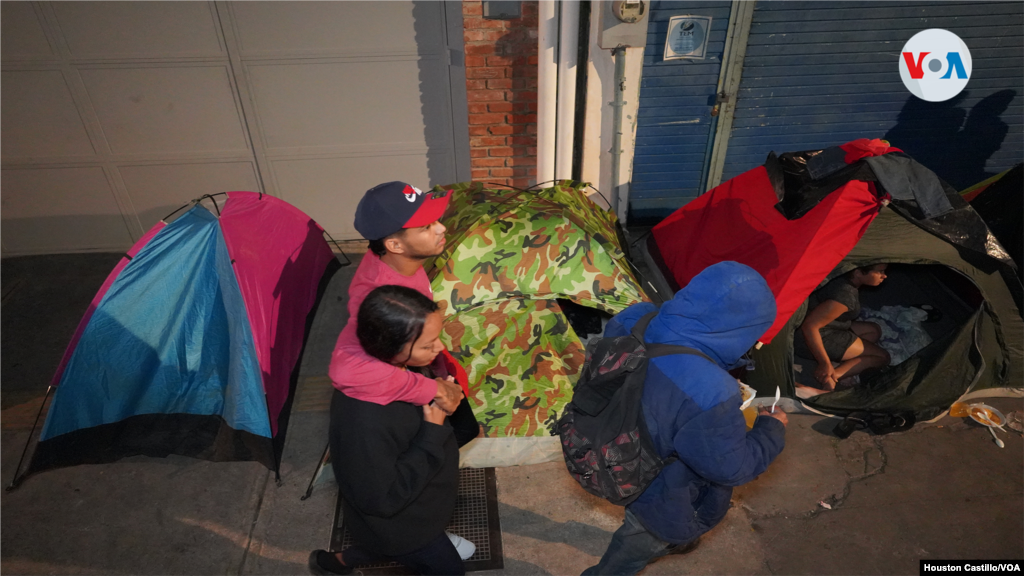 Un grupo de venezolanos busca su "casa de campaña" luego de recibir comida de organizaciones no gubernamentales en San José, Costa Rica. Foto Houston Castillo, VOA