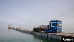 Sejumlah truk bergerak melewati dermaga sementara yang dibangun untuik mengirimkan bantuan ke Gaza, pada 19 Mei 2024. (Foto: U.S. Army Central/Handout via Reuters)