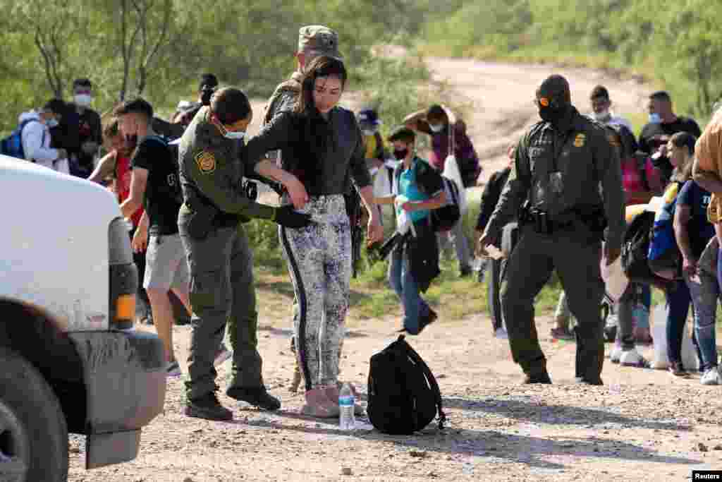 Agentes de aduanas procesan a migrantes, en su mayoría provenientes de Venezuela y Cuba, en Eagle Pass, Texas, lugar al que llegaron luego de cruzar el Río Grande.