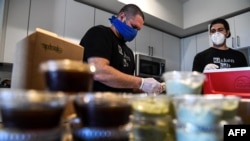 Muchos jóvenes venezolanos han dejado el país en busca de libertades y mayores oportunidades. En la fotografía aparecen Rafael Delgado, de 29 años (der) y su socio Mario Amate (31), exempleados de Uber, ahora laboran en el sector gastronómico en Miami. [Foto: Archivo]