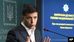 Ukrainian President Volodymyr Zelensky gestures as he speaks during a joint press conference held with the Chief of the Ukrainian National Police in Kyiv on July 23, 2019.