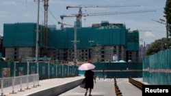 一名女子走过北京的一处住宅楼建筑工地。（2022年7月15日）