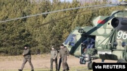 Miembros de la delegación ucraniana desembarcan de un helicóptero cuando llegan para conversar con representantes rusos en la región de Gomel, Bielorrusia, 28 de febrero de 2022. Sergei Kholodilin/BelTA/Foto vía REUTERS.
