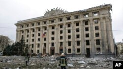 Un miembro del Servicio de Emergencia de Ucrania observa el edificio del ayuntamiento en la plaza central luego del bombardeo en Kharkiv, Ucrania, el martes 1 de marzo de 2022.