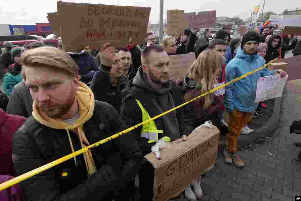 People holding placards offer transportation to refugees from Ukraine at the Korczowa border crossing, Poland, Feb. 27, 2022.