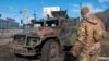A Ukrainian soldier inspects a damaged military vehicle after fighting in Kharkiv, Feb. 27, 2022. 