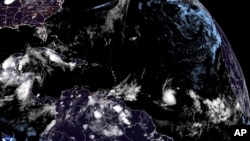 Esta imagen de satélite de la Oficina Nacional de Administración Oceánica y Atmosférica de EEUU tomada el sábado 29 de junio de 2024 a las 3:10am GMT muestra a la tormenta tropical Beryl, en el cuadrante inferior derecho cerca del centro, mientras avanza por el océano Atlántico