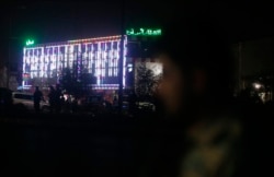Afghan police men stand guard outside the wedding hall after an explosion in Kabul, Afghanistan, Aug.18, 2019.