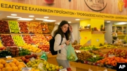 ARCHIVO - La entrenadora personal Antonia Kalantzi, de 38 años, compra en un supermercado en Atenas, el 16 de febrero de 2022.