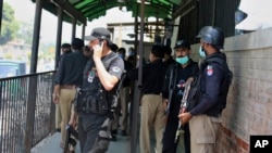Polisi Pakistan berkumpul di pintu masuk pengadilan negeri menyusul pembunuhan Tahir Shamim Ahmad, yang diadili dituduh menghina Islam. Polisi Pakistan pada 18 Mei mengatakan mereka menggagalkan upaya sekelompok orang untuk menghukum tersangka penistaan ​​agama. (Foto: AP)